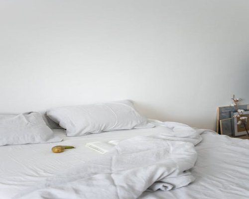 A tranquil bedroom interior with neutral tones and clean linens inviting restorative sleep