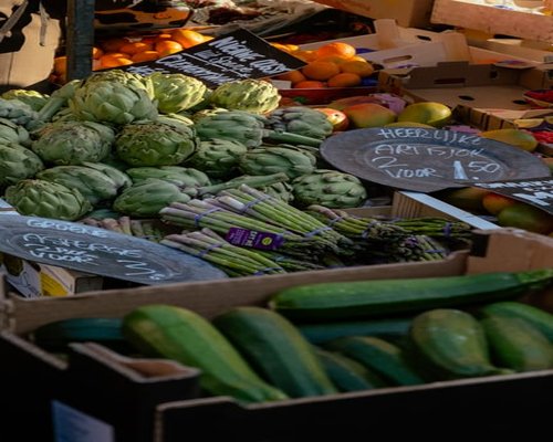 Fresh green produce and raw grains arranged neatly on a clear surface, depicting local market choices